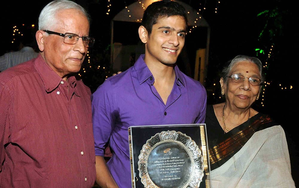 Asiad medalist Squash player Sourav Ghosal with his parents Rajendranath Ghosal (L) and Bina during a felicitation programme in Kolkata.
