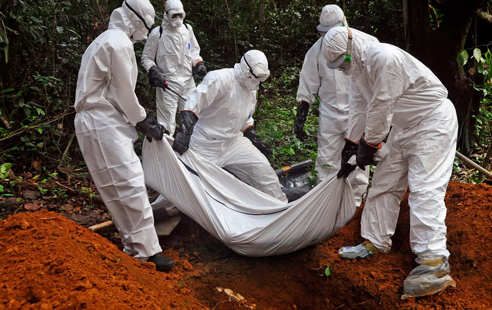 Health workers bury the body of a woman who is suspected of having died of the Ebola virus in Bomi county, on the outskirts of Monrovia, Liberia.