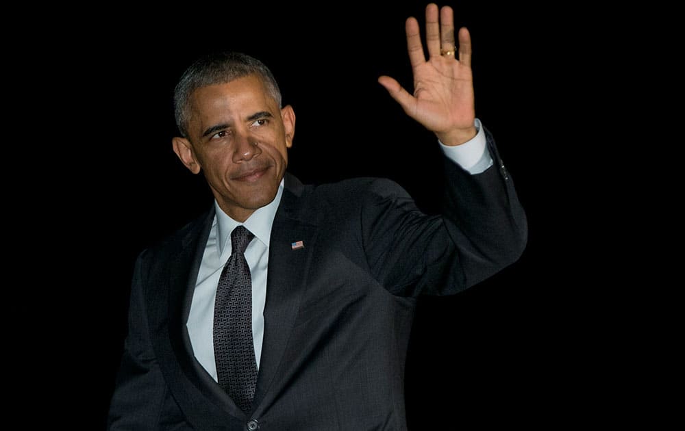 President Barack Obama waves as he walks from Marine One, across the South Lawn to the White House in Washington, as he arrives from Chicago.