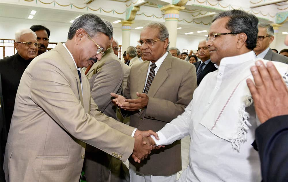 Karnataka Chief Minister Siddaramaiah shakes hand with Chief Justice H.L. Dattu during a felicitation function in Bengaluru.