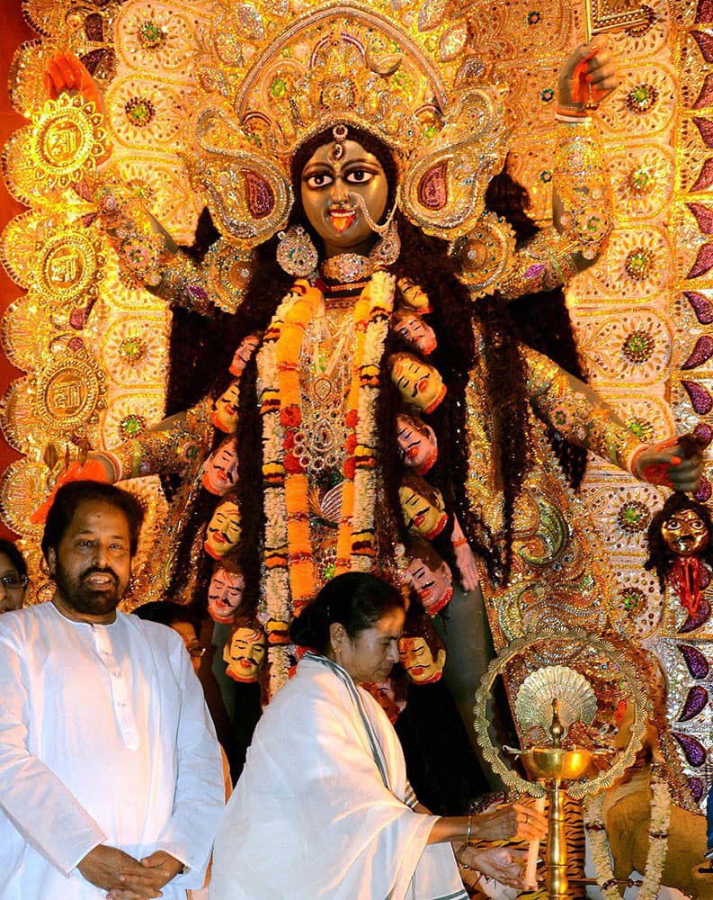 West Bengal Chief Minister Mamata Banerjee lighting lamp during inauguration of Kali Puja at Girish Park puja pandal in Kolkata on Monday on the occasion of Diwali festival. 