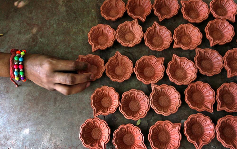 An Indian blind girl arranges earthen lamp casings ahead of Diwali festival in Ahmadabad.