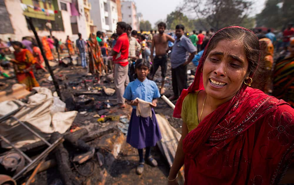 Sabina, only one name available, cries as she stands in the debris of homes destroyed by a fire at a slum in Gurgaon, India. There were no casualties reported. The cause of the fire is unknown.