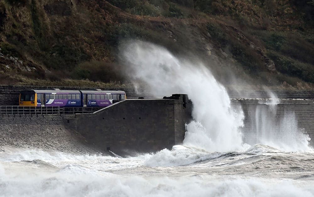 A train makes it's way along the coastal route near Whitehaven, north west England, as the remnants of Hurricane Gonzalo blew into Britain, causing rush-hour travel misery for road, rail and air travellers.  Some areas were subjected to gusts of wind up to 65 mph, (105 kph) but forecasters predicted that the worst of the weather will be over after by Wednesday.