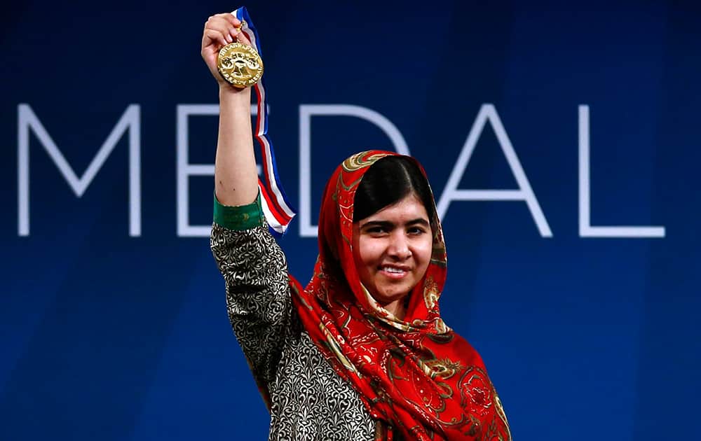 Malala Yousafzai holds up her Liberty Medal during a ceremony at the National Constitution Center, in Philadelphia. The honor is given annually to an individual who displays courage and conviction while striving to secure liberty for people worldwide.