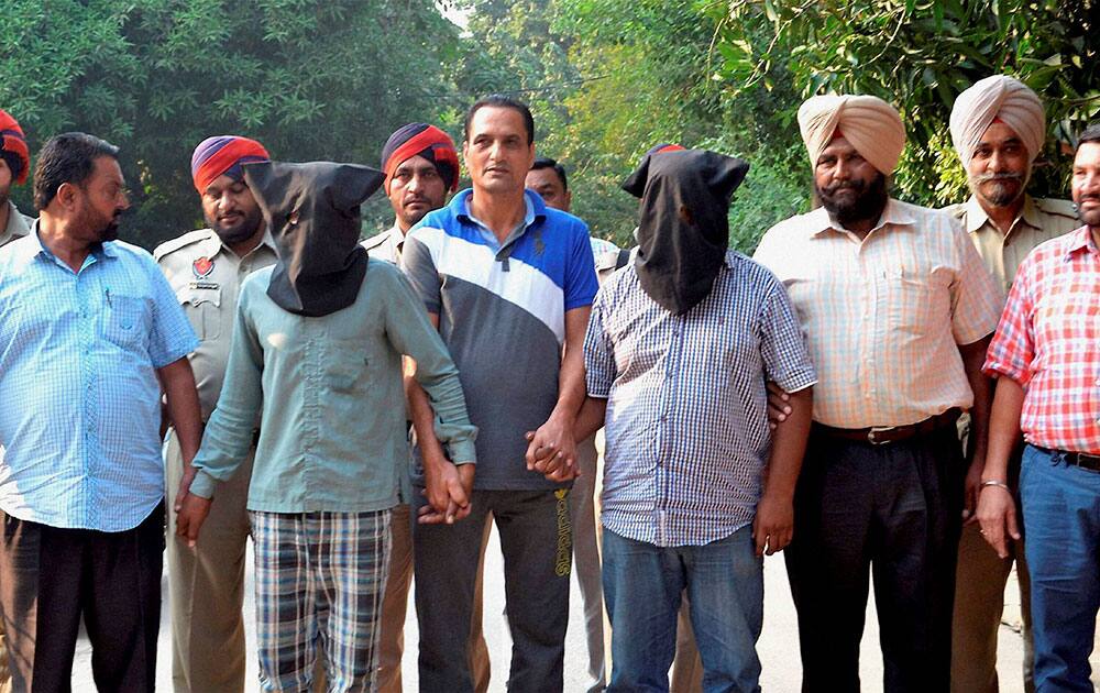 Police take away kidnappers of a 7-yr old after their arrest in Jalandhar.