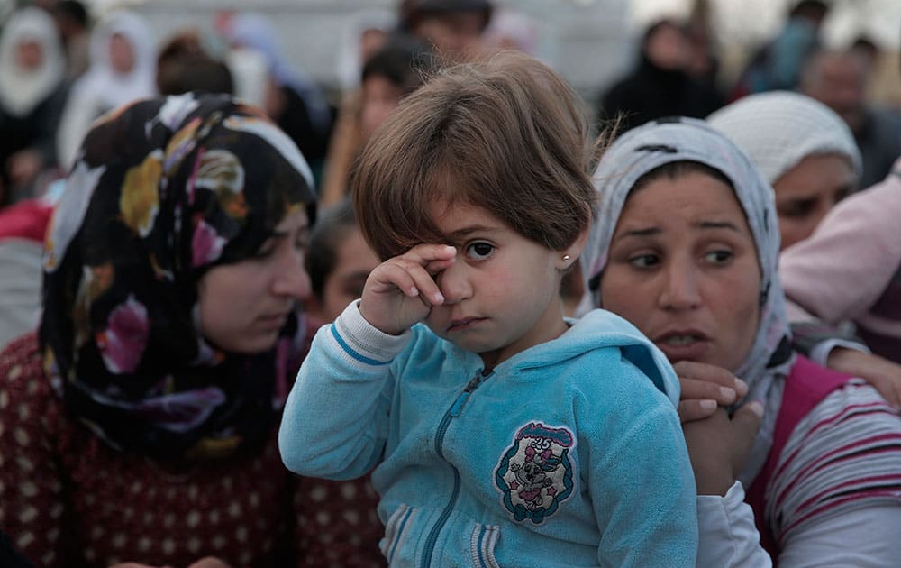 Kurdish mourners gather for the funeral of five Kurdish fighters, killed in the fighting with the militants of the Islamic State group in Kobani, Syria, at the cemetery in Suruc, on the Turkey-Syria border.