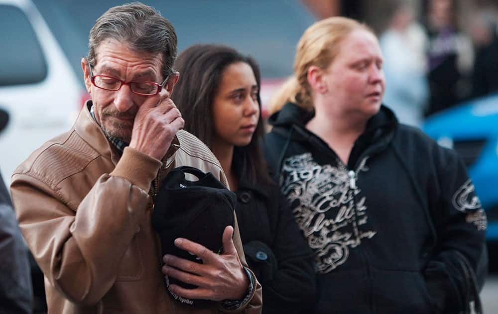 A man wipes his eyes at a memorial outside the gates of the John Weir Foote Armory, the home of the Argyll and Sutherland Highlanders of Canada in Hamilton, Ontario, in memory of Canadian soldier Nathan Cirillo.