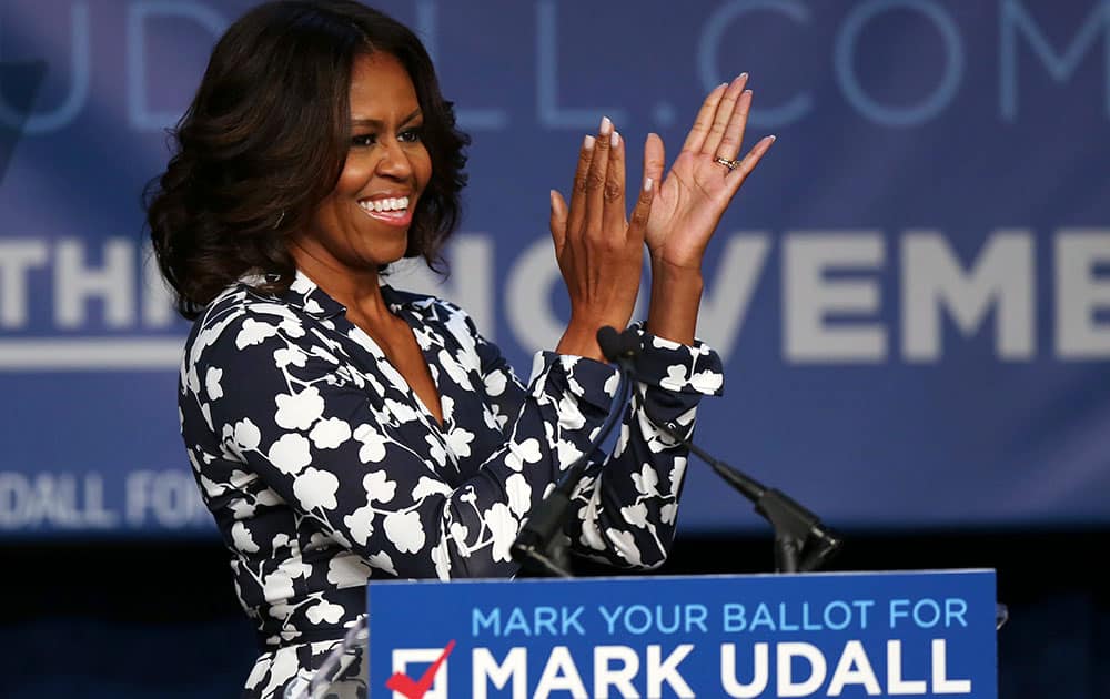 First lady Michelle Obama applauds on way to podium to speak during rally for re-election of Sen. Mark Udall, D-Colo., in Denver.