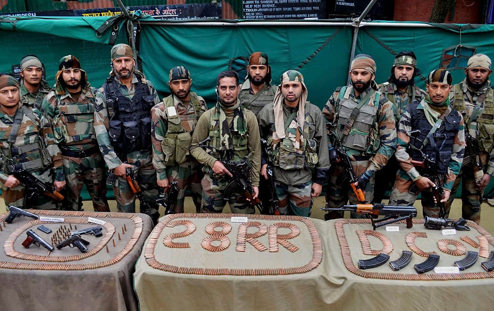  Army soldiers display arms and ammunition recovered from a militant’s hideout during a search operation in forest area of Lolab.