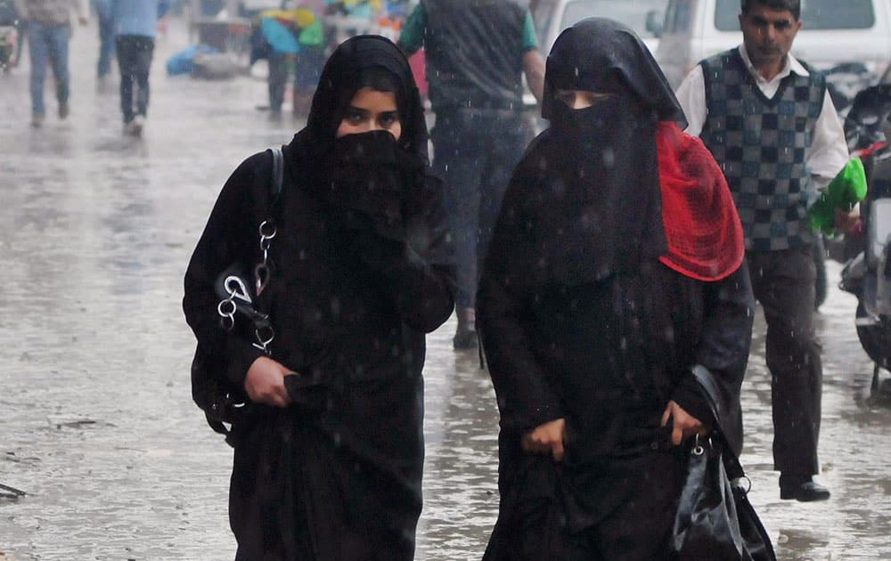 Srinagar: Women walk in drizzle.