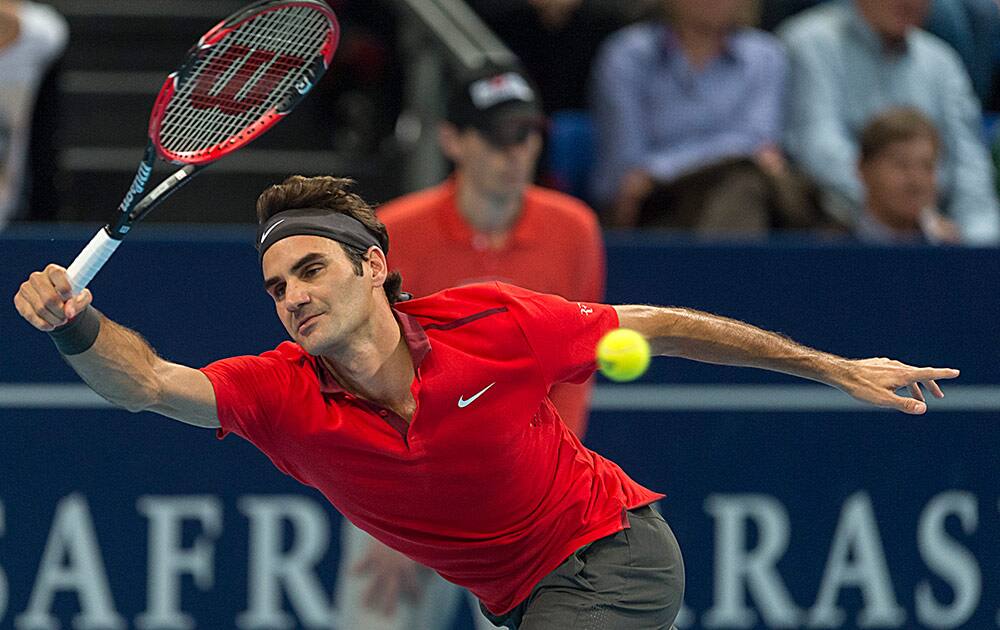 Switzerland's Roger Federer returns a ball to Bulgaria's Grigor Dimitrov during their quarterfinal match at the Swiss Indoors tennis tournament at the St. Jakobshalle in Basel, Switzerland.