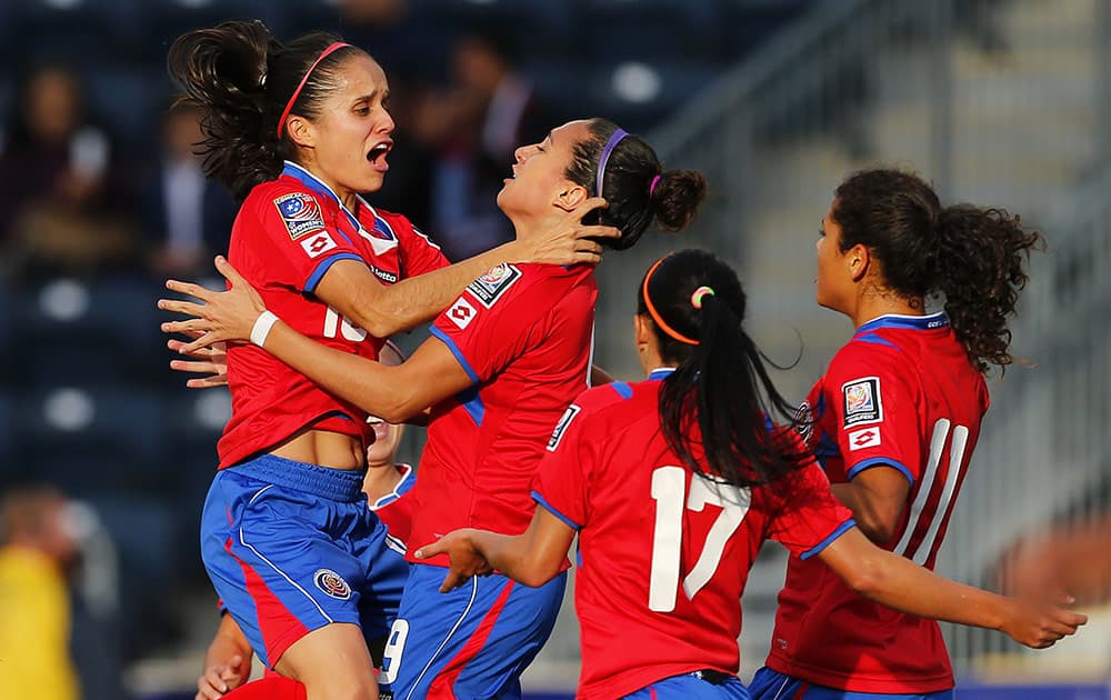 Costa Rica midfielder Katherine Alvarado (16) jumps into the arms of forward Carolina Venegas (9) after Venegas' goal in the first half against Trinidad and Tobago during a CONCACAF semifinal soccer match in Philadelphia, Pa