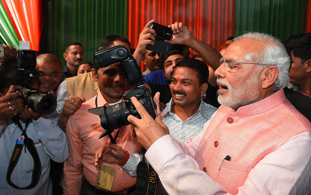 Prime Minister Narendra Modi clicks photographs during the Diwali Mangal Milan programme at BJP headquarters in New Delhi.