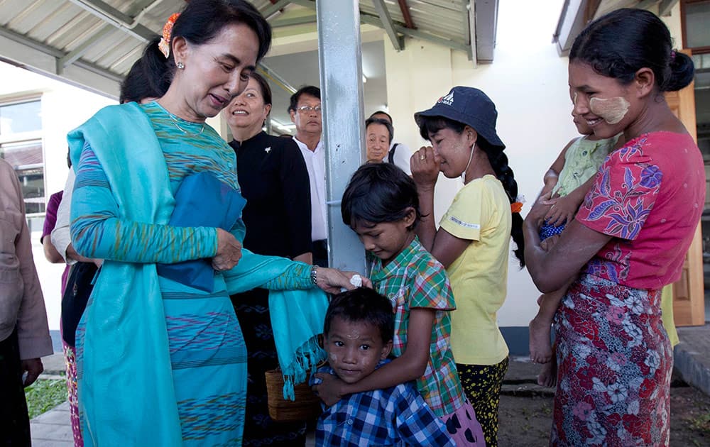 Myanmar opposition leader Aung San Suu Kyi, greets her supporters during the opening ceremony of Hospitality and Catering Training Academy of Daw Khin Kyi Foundation, late mother of Suu Kyi, in Kaw-Hmu, her constituency for a parliament seat, in Yangon, Myanmar.