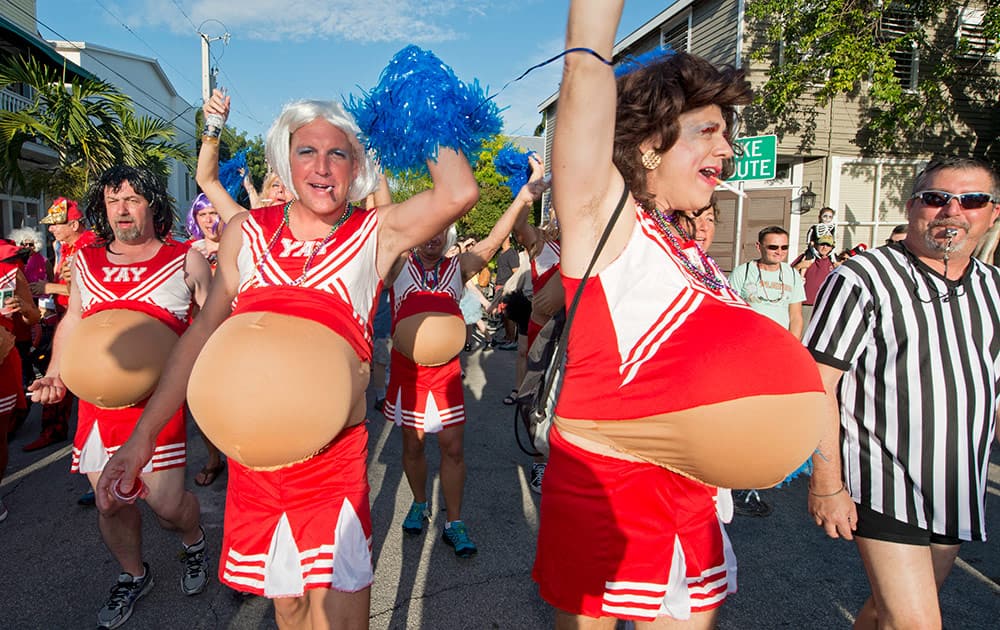 Men costumed as pregnant cheerleaders prance down Fleming Street in Key West, Fla., during the Fantasy Fest Masquerade March.