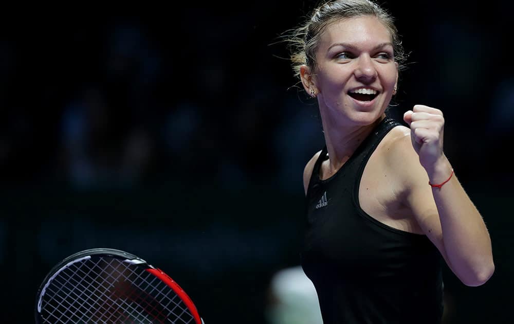 Romania's Simona Halep celebrates after defeating Poland's Agnieszka Radwanska in their semifinal match at the WTA tennis finals in Singapore.