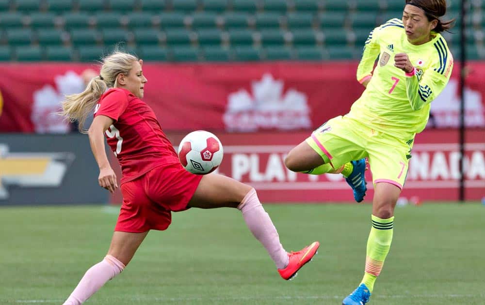 Japan's Kozue Ando (7) and Canada's Josee Belanger (9) compete for the ball during second half of an international friendly match in Edmonton, Alberta.