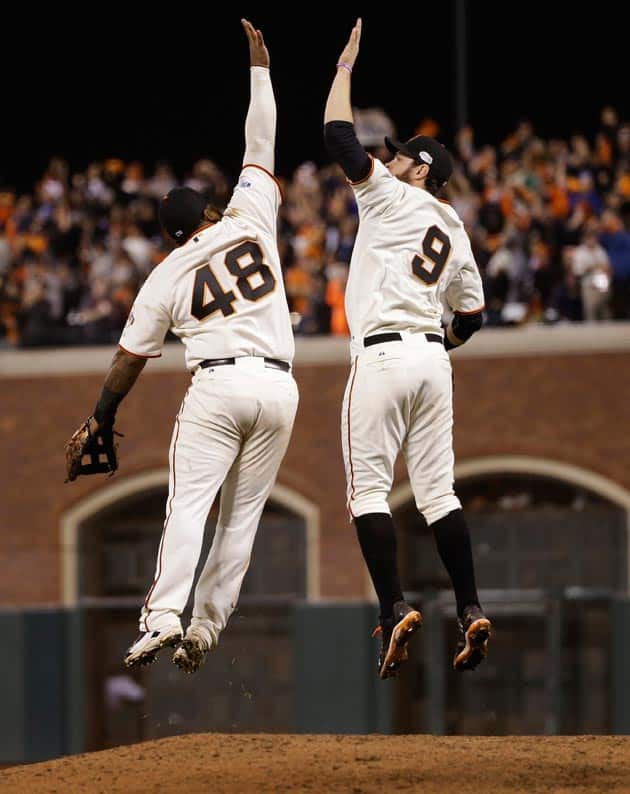 San Francisco Giants Pablo Sandoval, left, leaps up to high five Brandon Belt after defeating the Kansas City Royals 11-4 in Game 4 of baseball's World Serie in San Francisco.