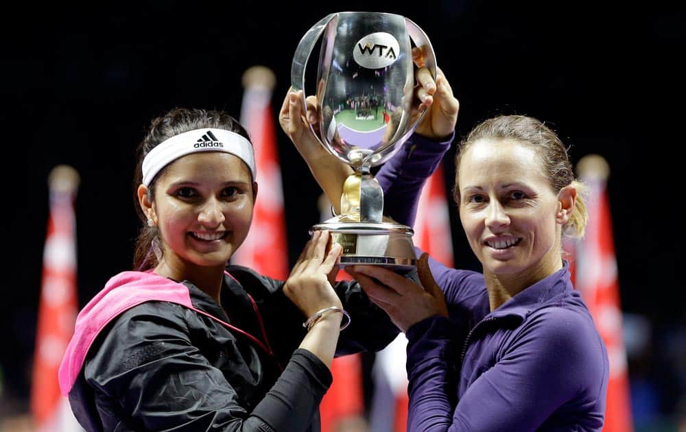 India's Sania Mirza, left, and Zimbabwe's Cara Black hold their trophy aloft after defeating Taiwain's Hsieh Su-Wei and China's Peng Shuai in the doubles final at the WTA tennis finals in Singapore.