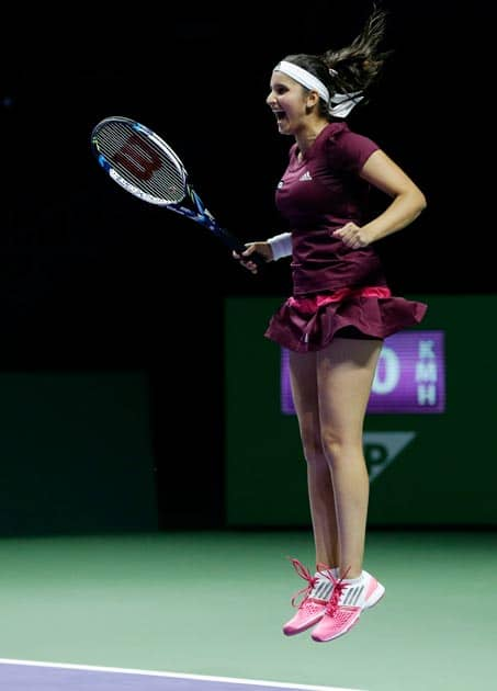 India's Sania Mirza jumps in the air as she celebrates with Zimbabwe's Cara Black, out of picture, after defeating Taiwain's Hsieh Su-Wei and China's Peng Shuai in the doubles final at the WTA tennis finals in Singapore.