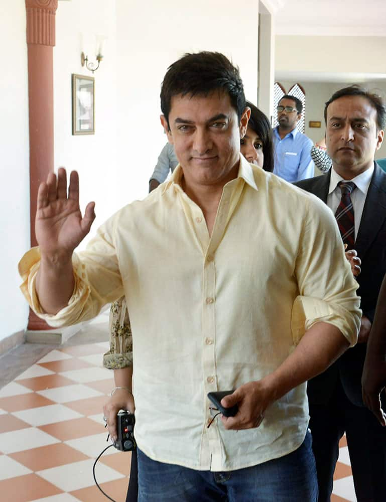 Bollywood actor Aamir Khan waver to the media as he arrives for Mumkin Hai, a special segment of Satyamev Jayate in Bhopal.