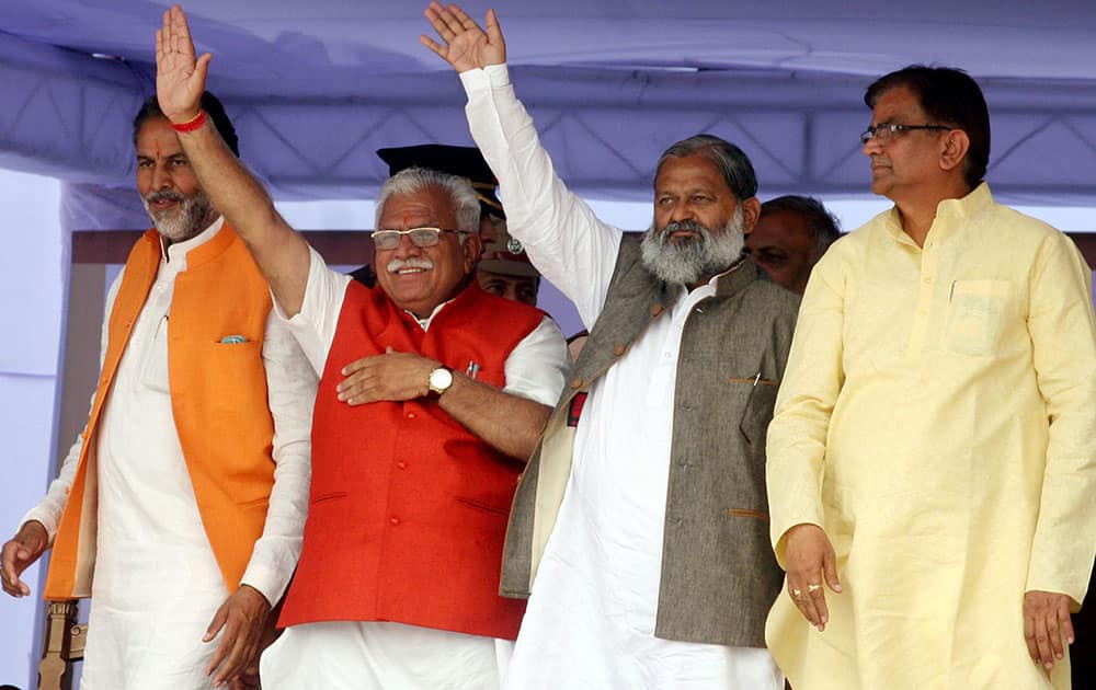 Chief Minister Manohar Lal Khattar along with the newly inducted Ministers wave after taking oath of office in Panchkula.