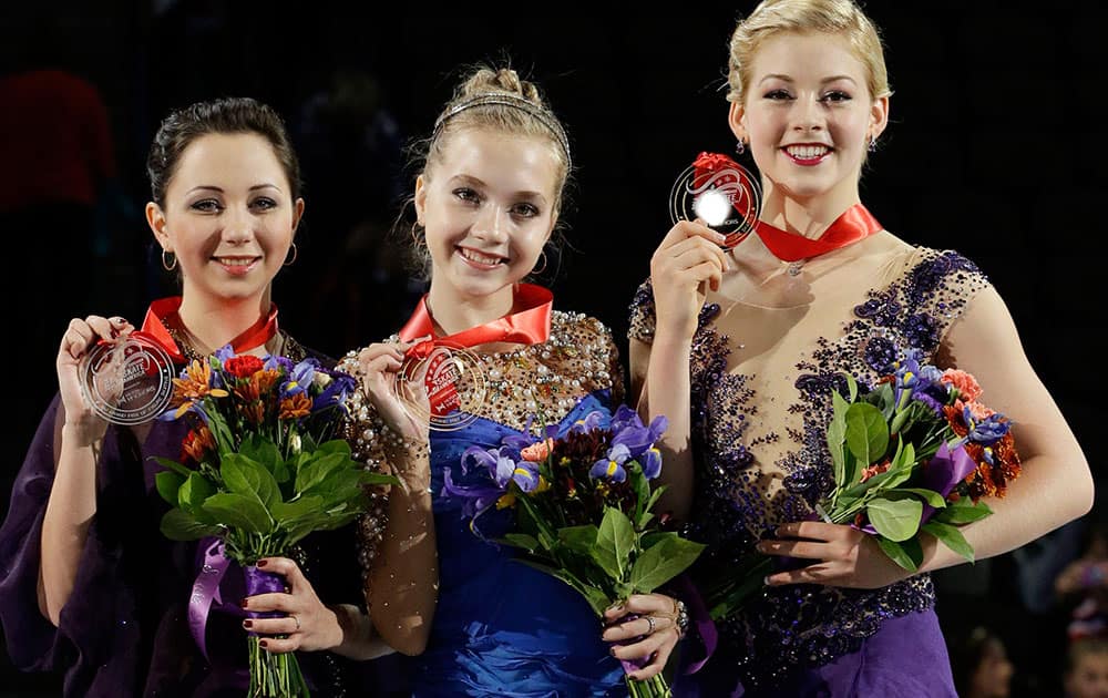 Gold medalist Elena Radionova, center, of Russia, silver medalist Elizaveta Tuktamysheva, left, of Russia, and bronze medalist Gracie Gold pose for photographers with their medals for the ladies skating program at the Skate America figure skating event at the Skate America figure skating event in Hoffman Estates, Ill. 