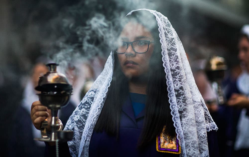 A woman carries a censer as during a procession honoring The Lord of Miracles `Senor de los Milagros` in Madrid, Spain.