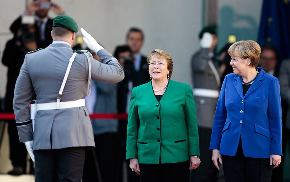 A honor guard, salutes as German Chancellor Angela Merkel, welcomes the President of Chile, Michelle Bachelet, at the chancellery in Berlin.
