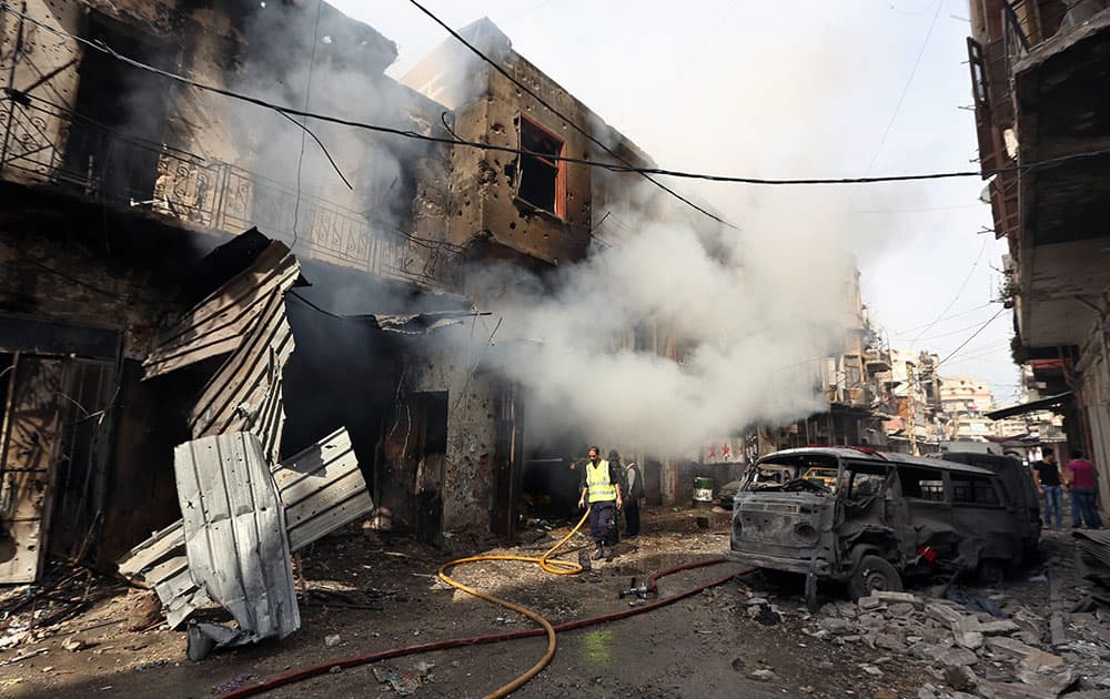 Lebanese firefighters extinguish burned shops that were attacked during clashes between the Lebanese army and Islamic militants in the northern port city of Tripoli, Lebanon.