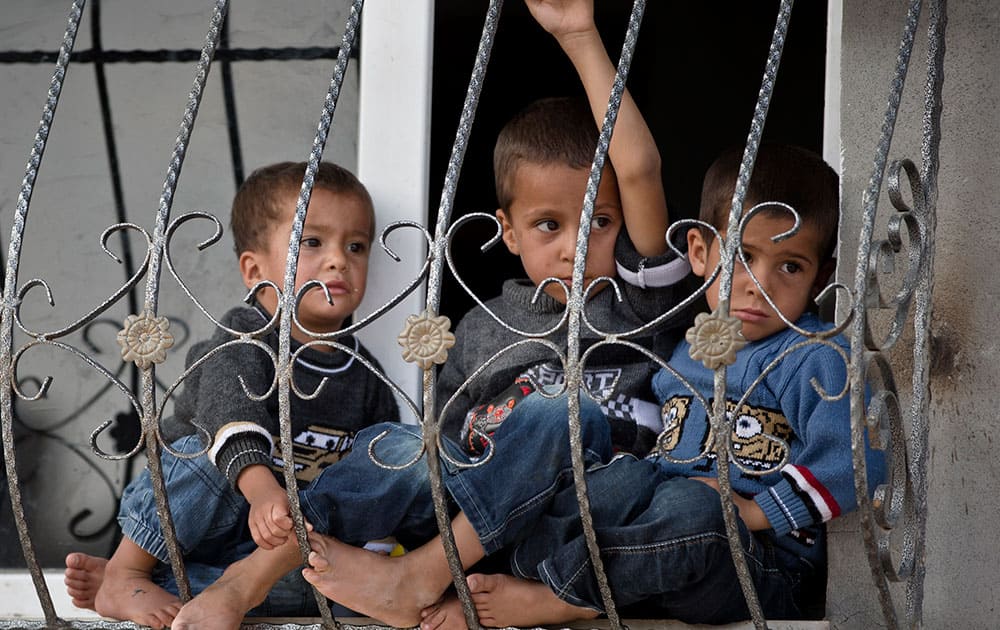 Kurdish children sit at a window in Suruc, on the Turkish side of the border with Syria, across from the Syrian town of Kobani.