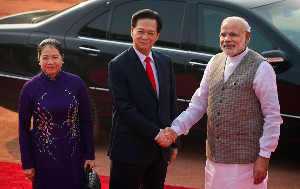 Vietnam Prime Minister Nguyen Tan Dung, center, and his wife, Tran Thanh Kiem, left, are received by Indian Prime Minister Narendra Modi during a ceremonial reception at the forecourt of the Indian President's palace in New Delhi.