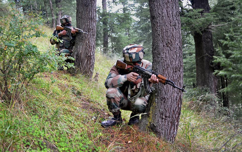 Army personnel take positions during an encounter with militants in the forest area.