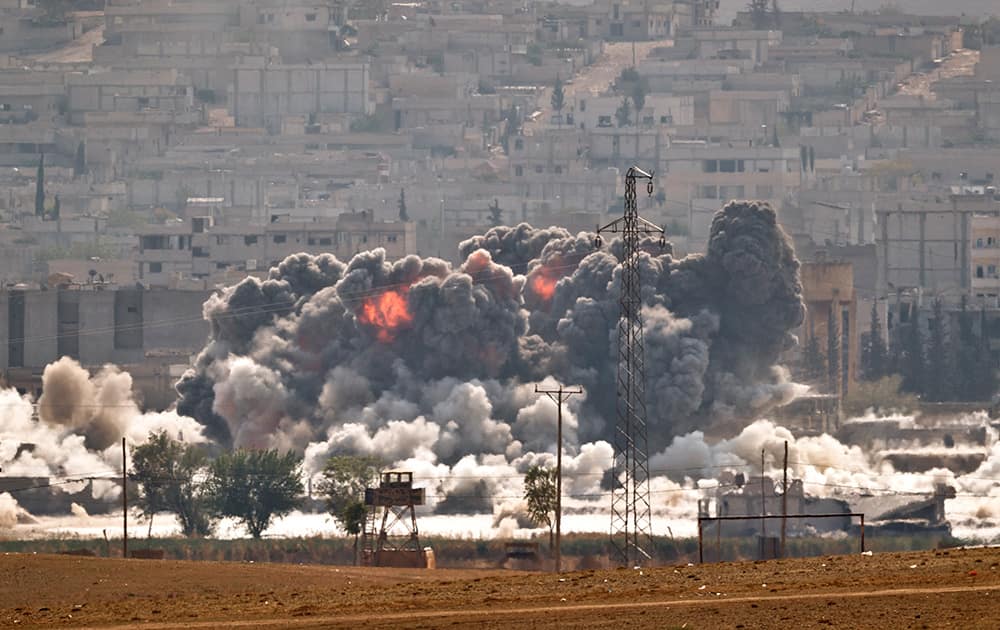 Smoke and flames rise from an Islamic State fighters' position in the town of Kobani during airstrikes by the US led coalition seen from the outskirts of Suruc, near the Turkey-Syria border. Kobani, also known as Ayn Arab, and its surrounding areas, has been under assault by extremists of the Islamic State group since mid-September and is being defended by Kurdish fighters.