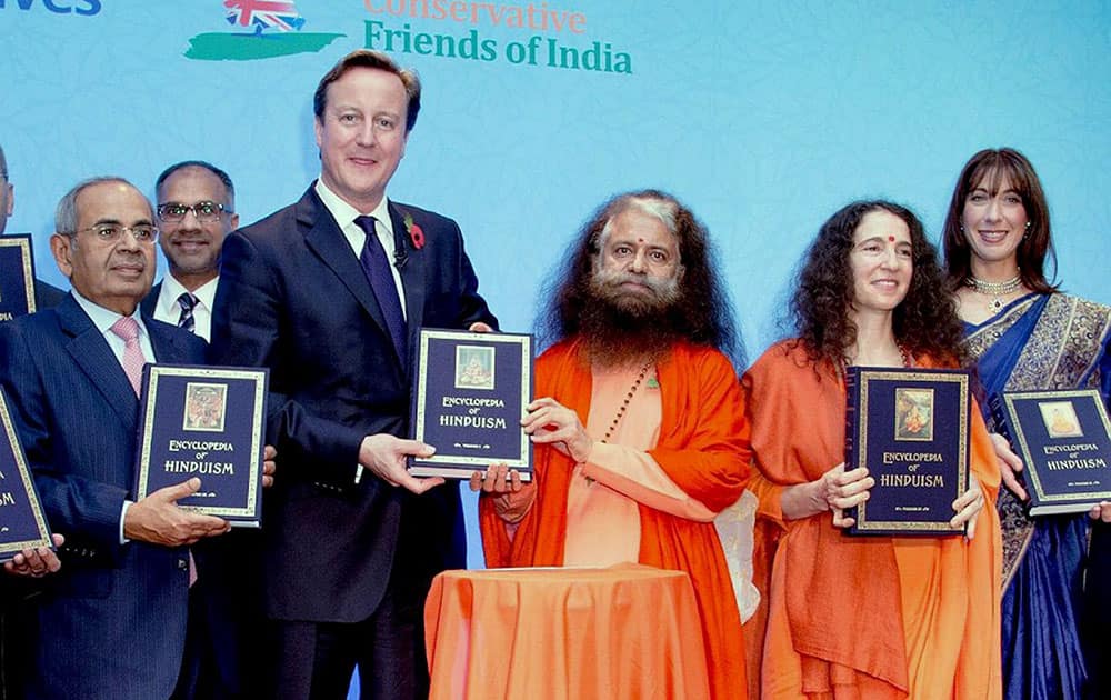 British Prime Minister David Cameron and his wife Samantha (in blue sari) along with Swami Chidanand Saraswati, Founder and Chairman of India Heritage Research Foundation, industrialist Gopi Chand Hinduja and others unveiling the first volume of The Encyclopedia of Hinduism in London.
