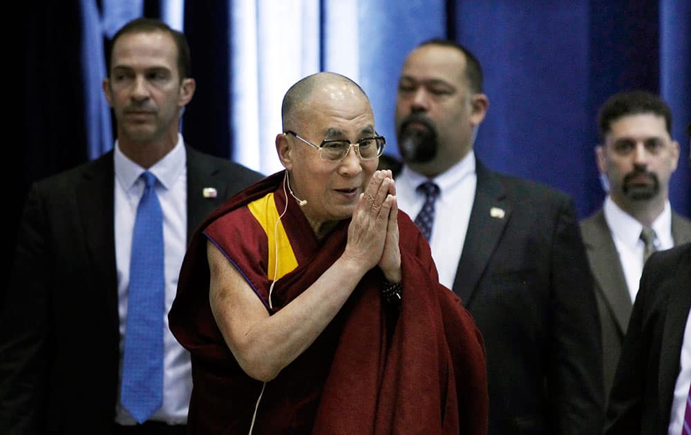 The Dalai Lama walks with security guards as he arrives to address a gathering at Princeton University in Princeton, N.J.