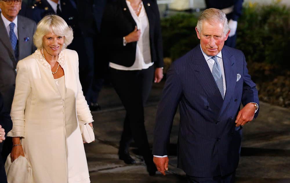 Britain's Prince Charles, right, and his wife Camilla, the Duchess of Cornwall walk by, upon their arrival at the military airport in Bogota, Colombia.