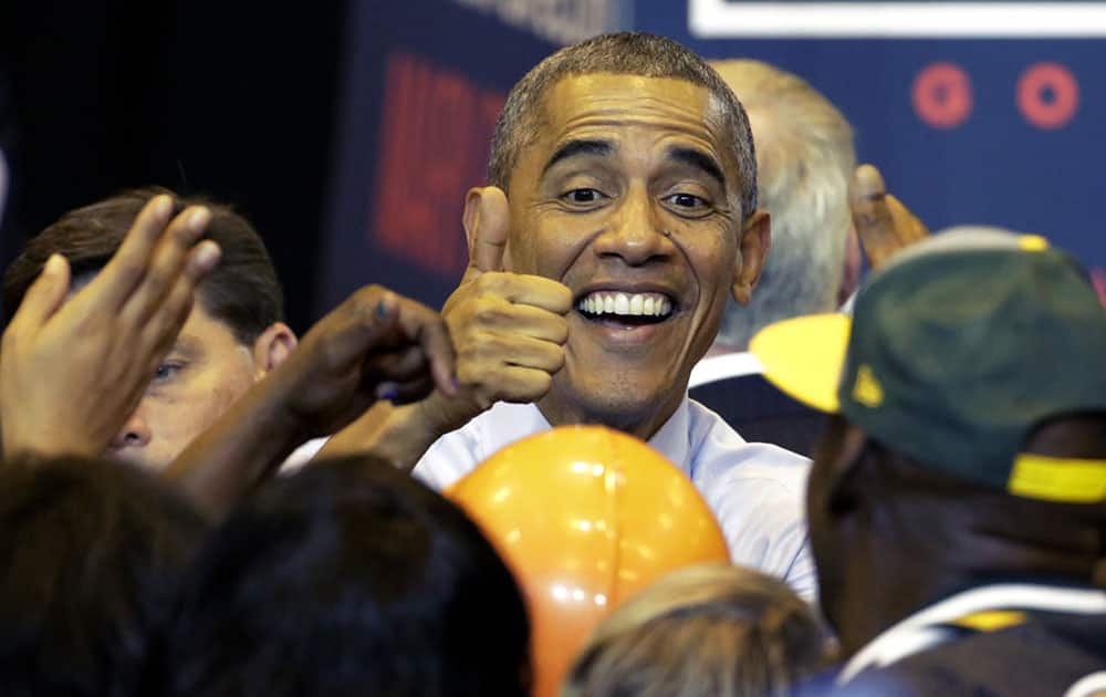 President Barack Obama gives a thumbs up to supporters as he campaigns for Wisconsin Democratic gubernatorial candidate Mary Burke during a rally at the North Division High School, in Milwaukee.