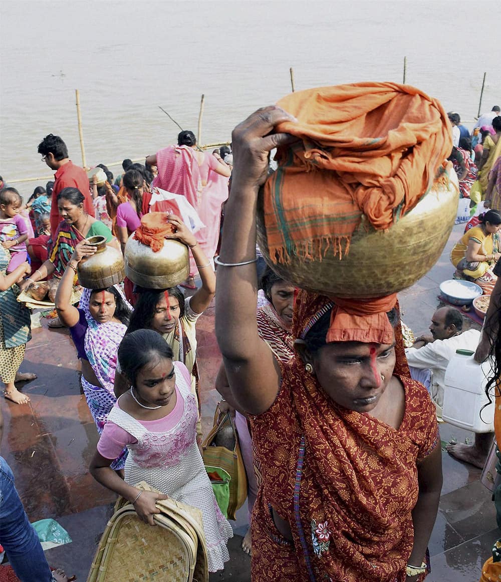 Women carry Ganga water for preparing prashad ahead of the four days long Chhath festiva,l in Patna.