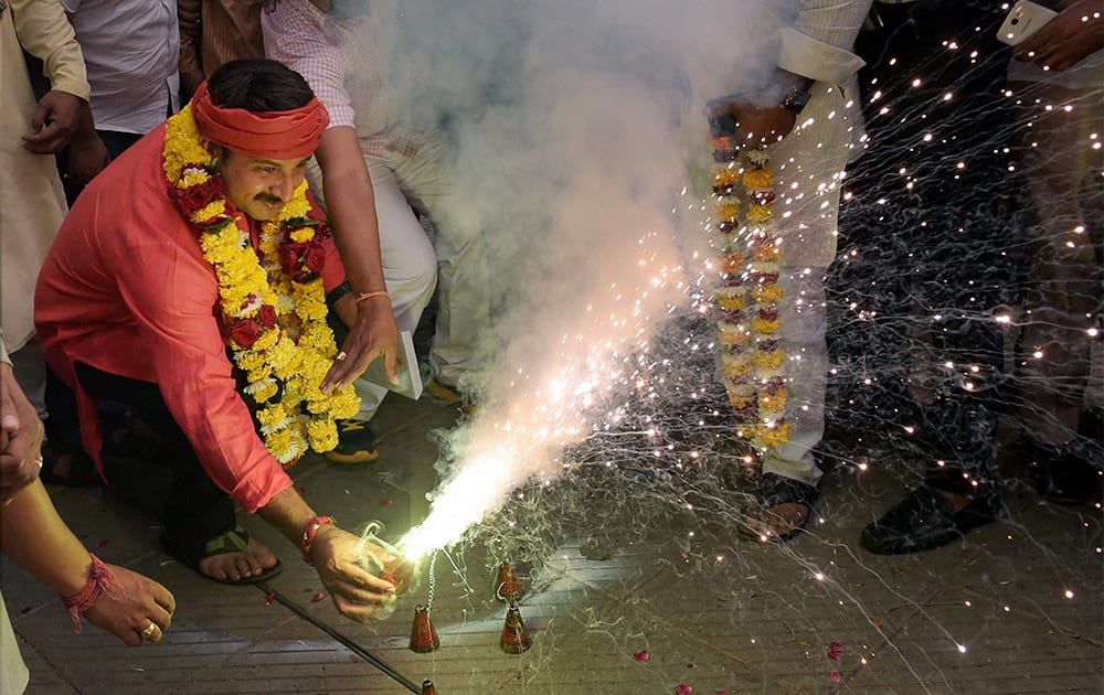 BJP MP Manoj Tiwari burns crackers as he celebrates with Purvanchalis after declaration of Chhath puja as a public holiday in Delhi.