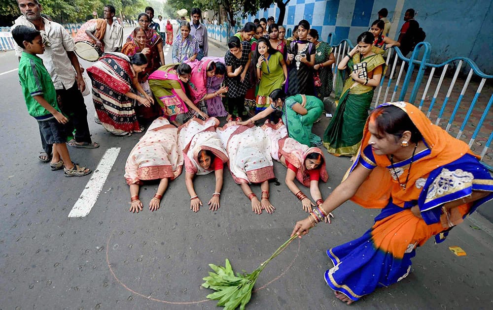 Devotees roll across the road towards river Ganga as part of the Chhath puja celebrations in Kolkata.