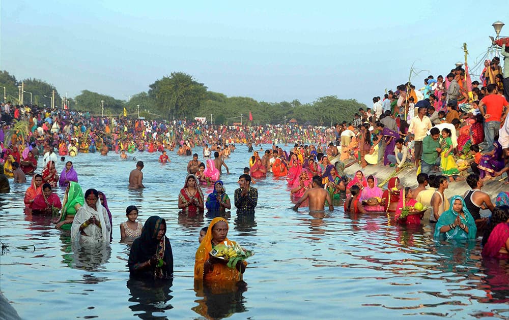 Devotees offer prayers to the sun after taking holy dip during Chhath festival in Chandigarh.