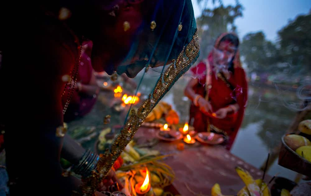 Hindu women perform rituals at sunset to mark Chhath Puja festival in New Delhi.