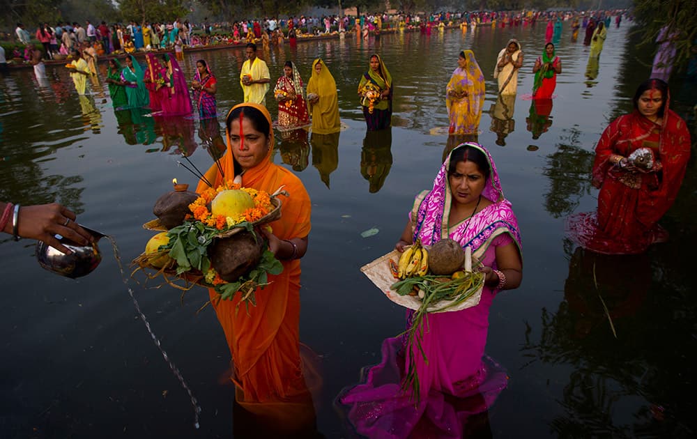 Hindu women perform rituals at sunset to mark Chhath Puja festival in New Delhi.