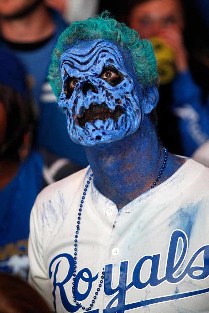 Dressed for Halloween, a Kansas City Royals fan watches Game 7 of the World Series in the Power and Light entertainment district in Kansas City, Mo.