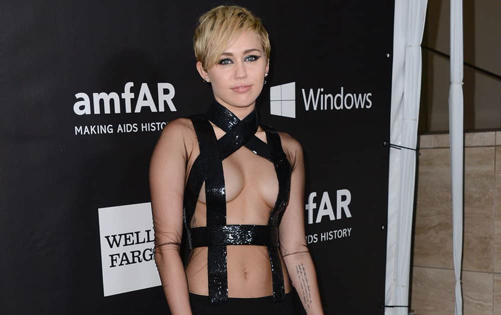 Miley Cyrus arrives at the 2014 amfAR Inspiration Gala at Milk Studios, in Los Angeles.