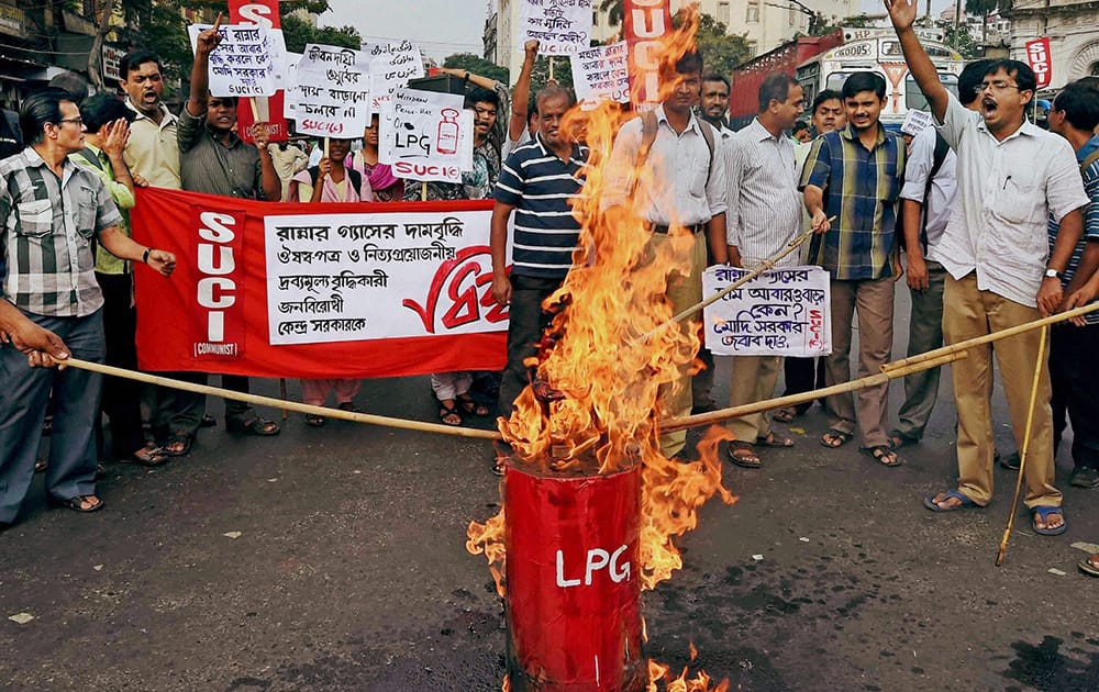 SUCI activists burn an effigy of LPG cylinder to protest against its price hike, in Kolkata.