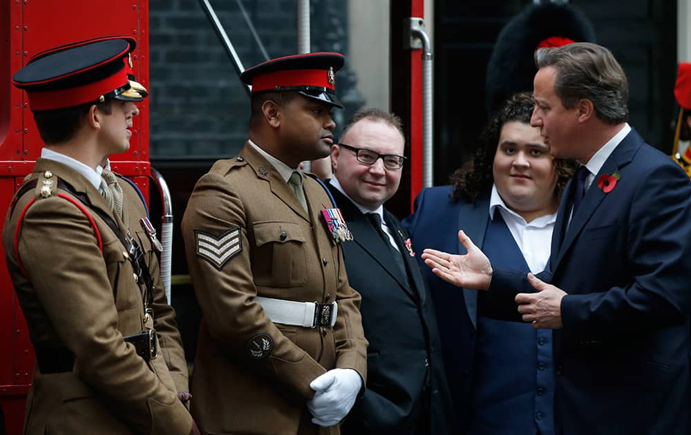 Johnson Gideon Beharry VC, second left, speaks to the British Prime Minister David Cameron outside 10 Downing Street during a event to mark the annual Poppy Day in London.