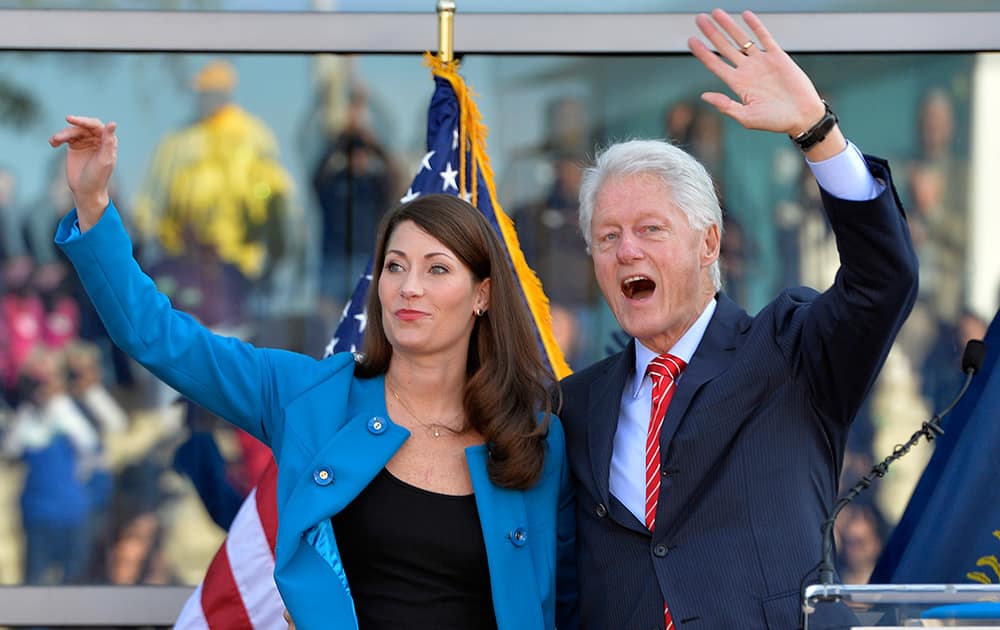 Former President Bill Clinton, right, and Kentucky Democratic senatorial candidate Alison Lundergan Grimes wave to the gathered supporters following a rally at the Muhammad Ali Center in Louisville, Ky.